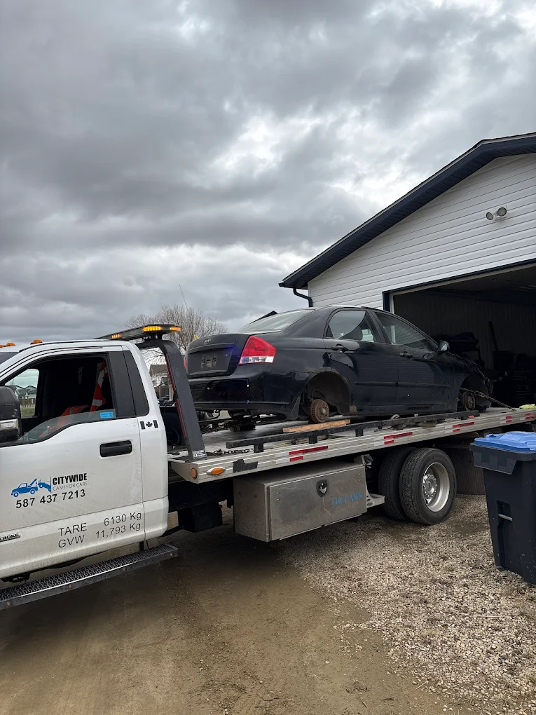 citywide-cash-for-cars-calgary Citywide Cash For Cars Tow truck transporting a junk car.